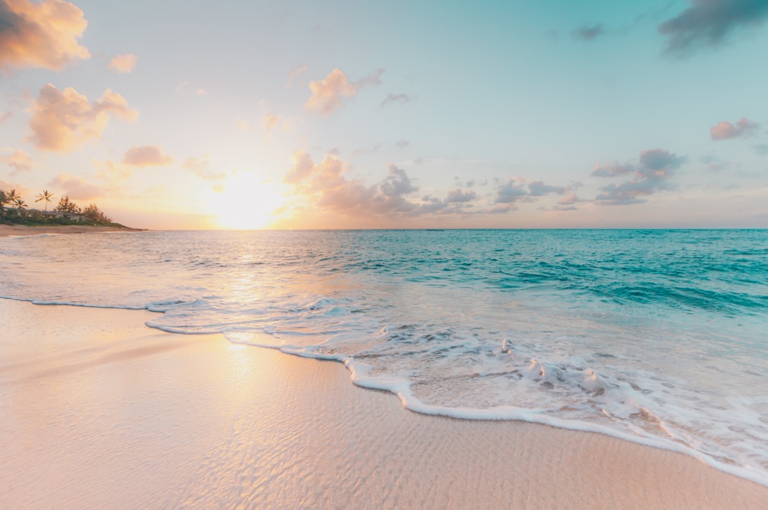 Praia paradisíaca com águas cristalinas ao pôr do sol
